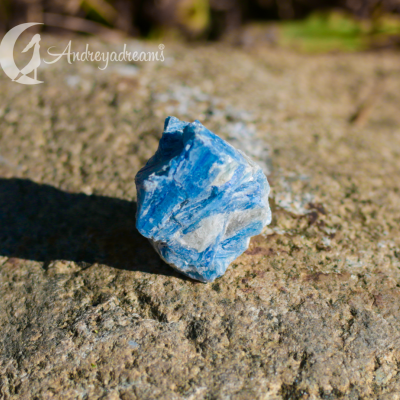 Pedra bruta azul com veios brancos sobre pedra em ambiente exterior