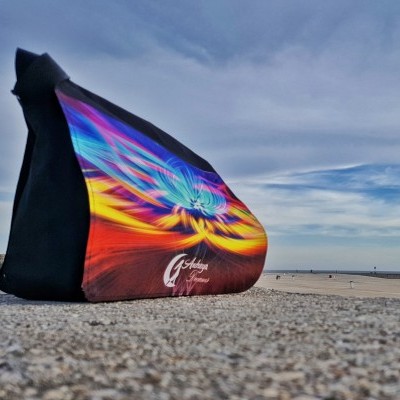 Saco colorido com padrão abstrato e texto Get together numa calçada exterior sob céu nublado