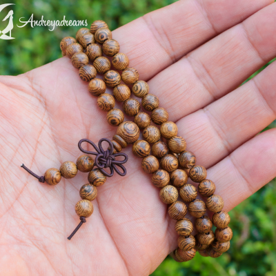 Contas de madeira castanhas com padrão natural em mão com fundo verde