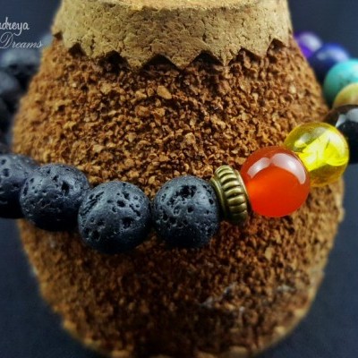 Pulseira com contas em lava vulcânica preta e coloridas brilhantes sobre suporte marrom