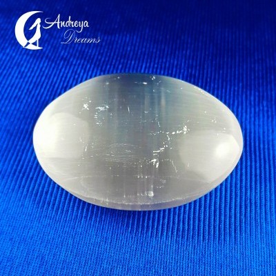 Pedra oval translúcida branca sobre tecido azul