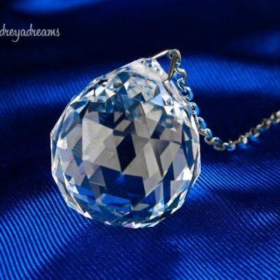 Colar com pendente em cristal facetado transparente sobre tecido azul