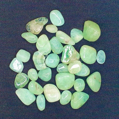 Pedras polidas verdes e azuis claro sobre fundo escuro