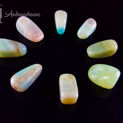 Oito pedras semipreciosas polidas dispostas em círculo em fundo preto com marca de água