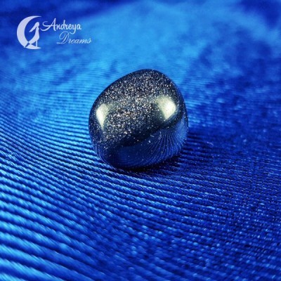 pedra polida brilhante sobre tecido azul com logótipo Androya Dreams