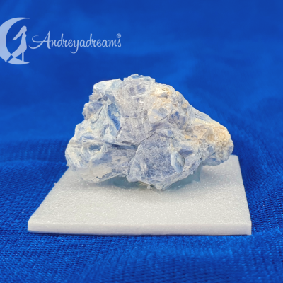 Cristal mineral azul claro sobre base branca em fundo azul