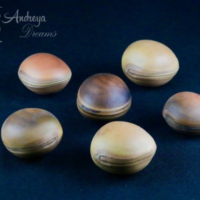 seis caixas redondas de madeira com tampas arredondadas sobre tecido azul escuro