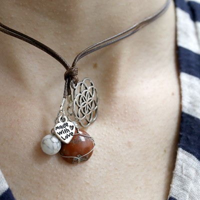 Colar com pendentes floral, pedras e placa 'Made With Love' em cordão castanho.