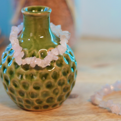 Vaso verde de cerâmica com textura e pulseira de pedras rosa