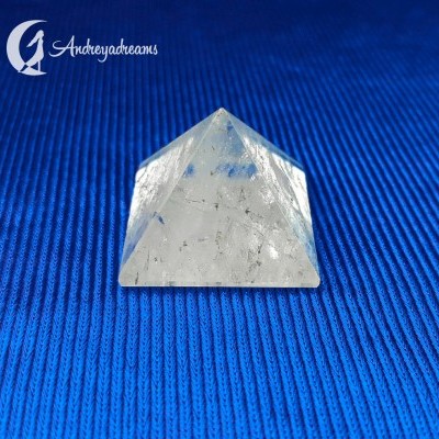 Pirâmide de cristal transparente sobre fundo azul texturizado