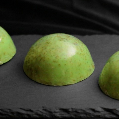 Bombons verdes meio-esféricos com manchas castanhas