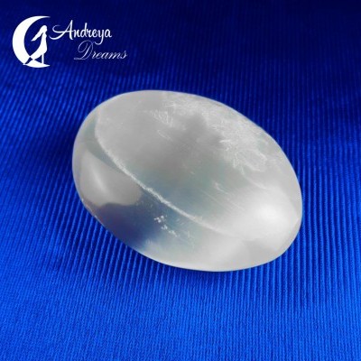 Pedra oval branca translúcida sobre fundo azul com logótipo Andreya Dreams