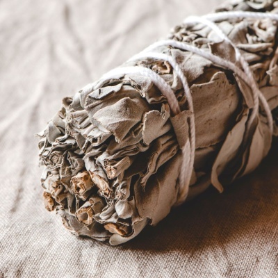 Trouxa de sálvia seca amarrada com cordas sobre pano bege