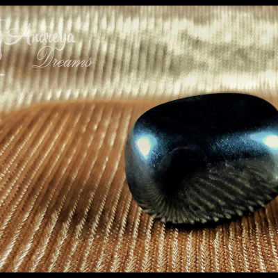 Pedra preta polida sobre tecido riscado castanho