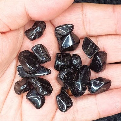 Mão com pedras pretas polidas com veios brancos