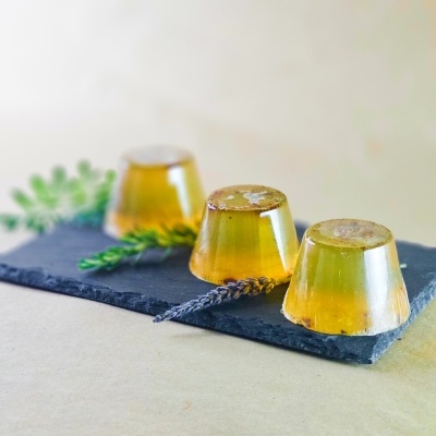 Sabonetes amarelos transparentes em base preta com raminhos decorativos