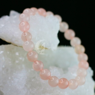 Pulseira de contas rosa claro sobre pedra branca