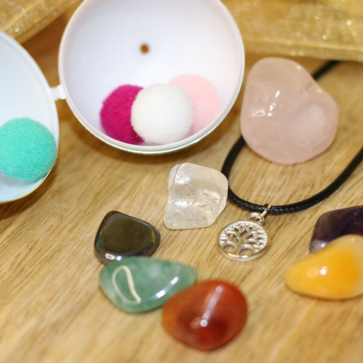 Pedras polidas coloridas e colar com pendente árvore da vida em fundo de madeira