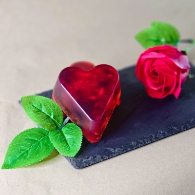 Sabonete em forma de coração vermelho com rosa artificial sobre base preta