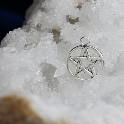 Medalha de pentagrama prateada sobre cristais brancos