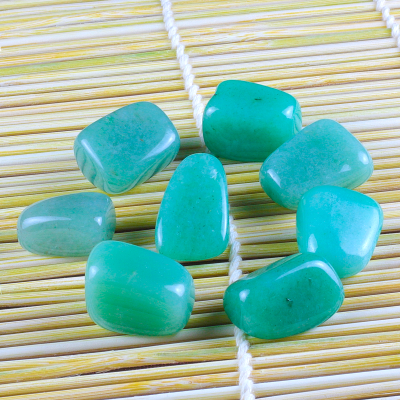 Oito pedras verdes polidas sobre esteira de palha