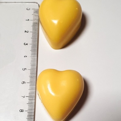 Dois corações amarelos e régua transparente com marcações em centímetros