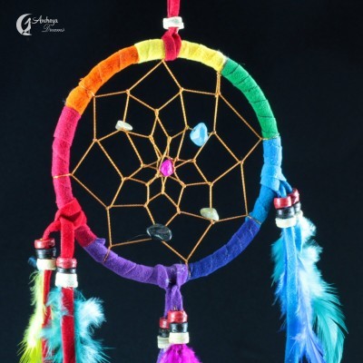 Apanhador de sonhos colorido com cristais e penas em fundo preto