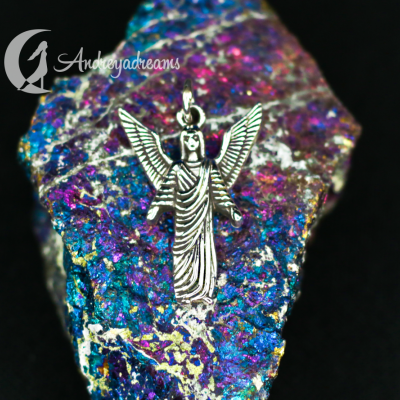 Colar prateado de anjo sobre mineral colorido iridescente