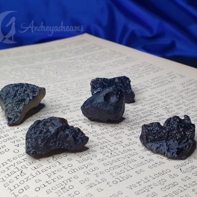 Cinco fragmentos de rochas negras sobre texto em português com fundo azul