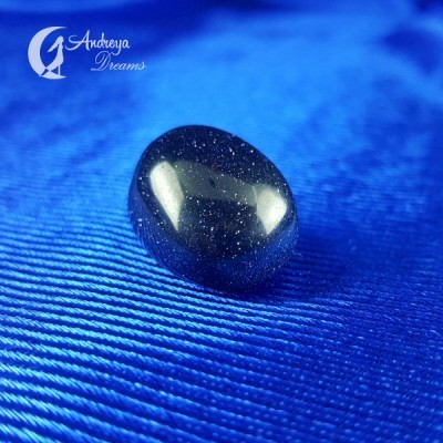 Pedra azul brilhante com glitter prateado sobre tecido azul com linhas horizontais