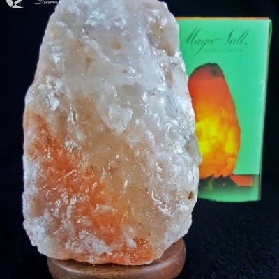 Lâmpada de sal do Himalaia com base de madeira e embalagem verde ao fundo