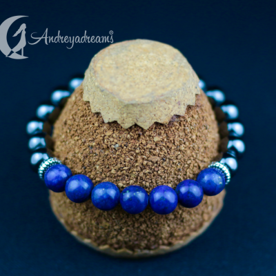 Pulseira azul e prateada em suporte de cortiça sobre fundo azul escuro