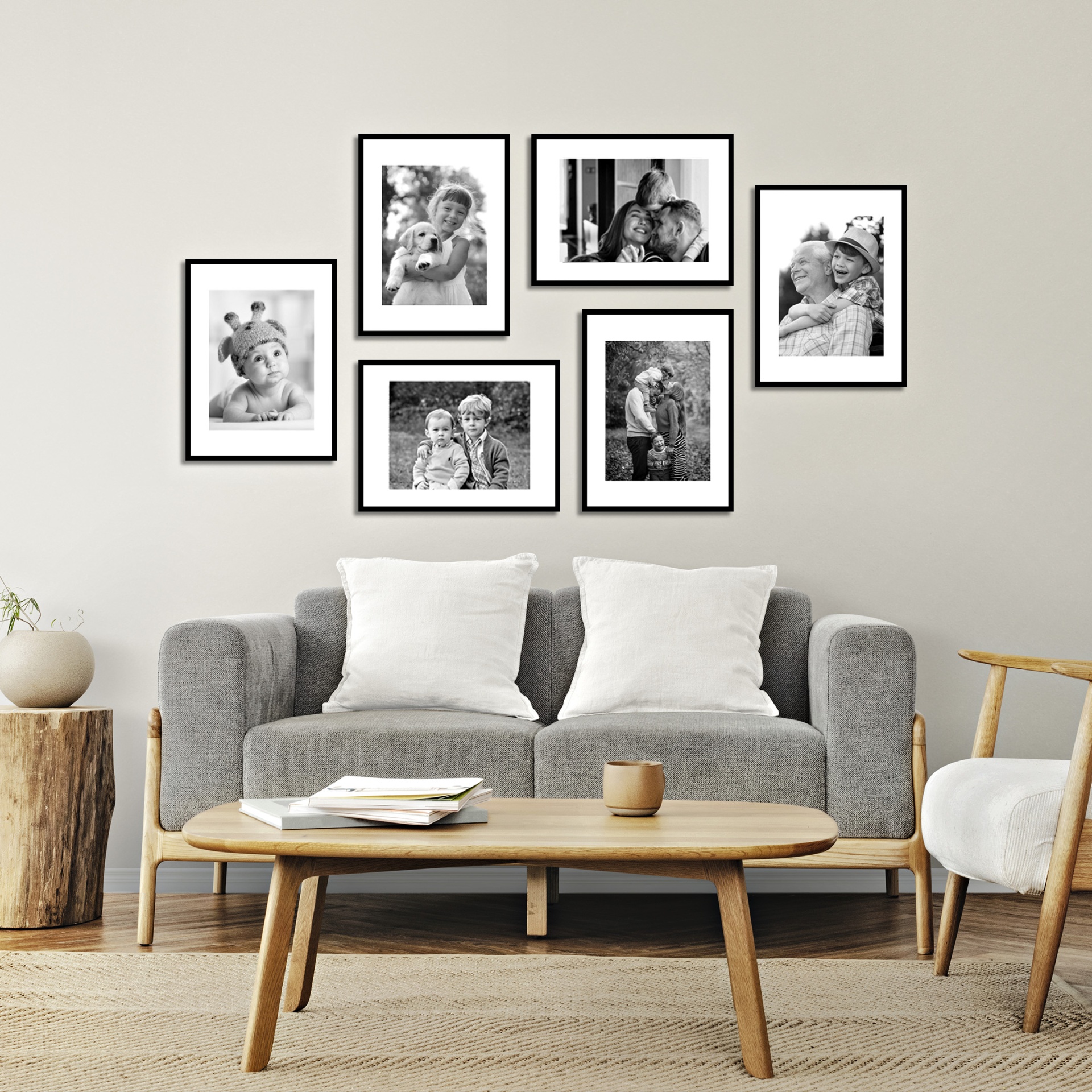 Sala de estar com sofás, mesa e molduras de fotografias em preto e branco