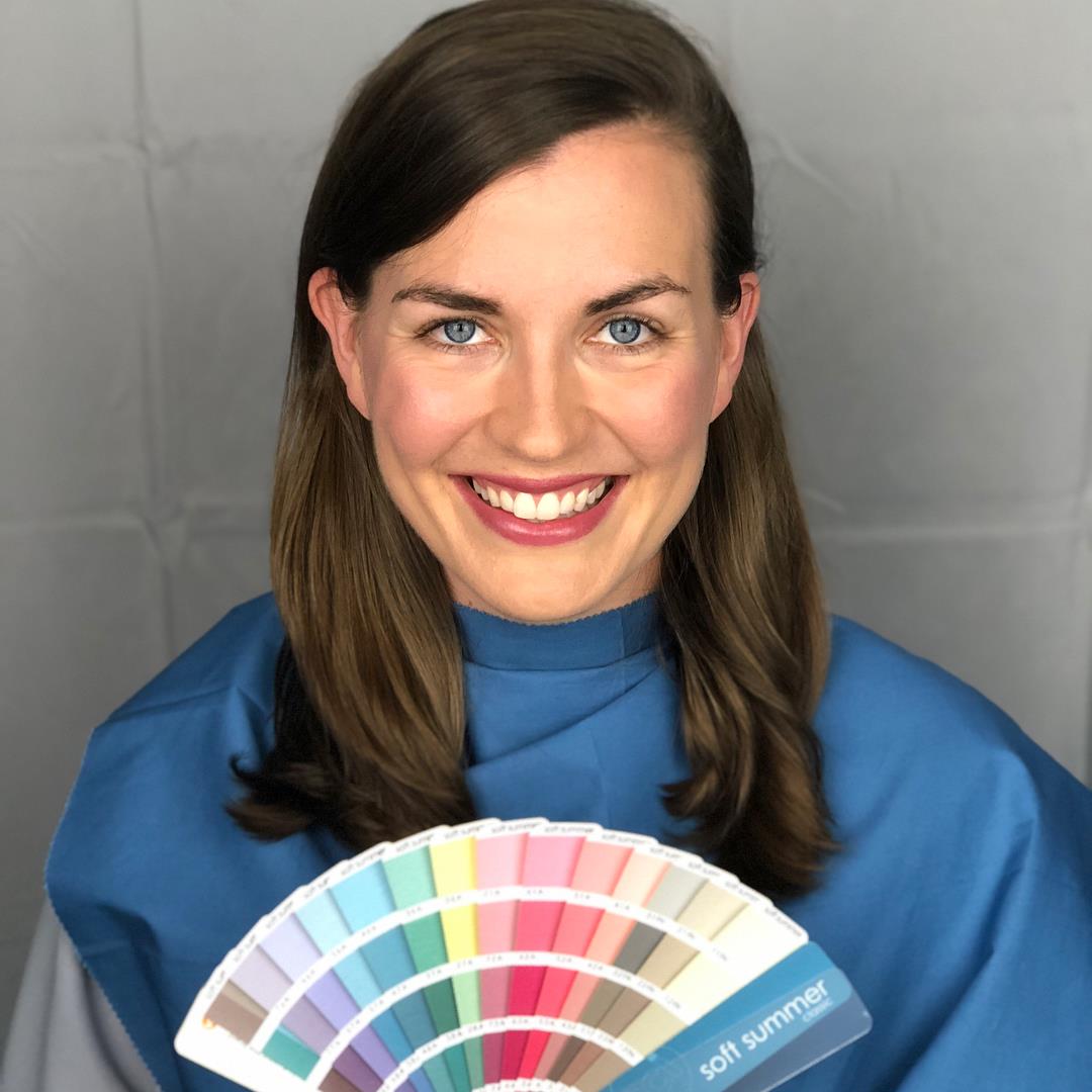 Mulher sorridente segurando leque de amostras de cores pastéis