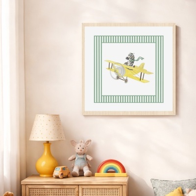 Quadro infantil com zebra e avião amarelo em moldura de madeira na parede acima de cómoda de madeira com candeeiro e peluches