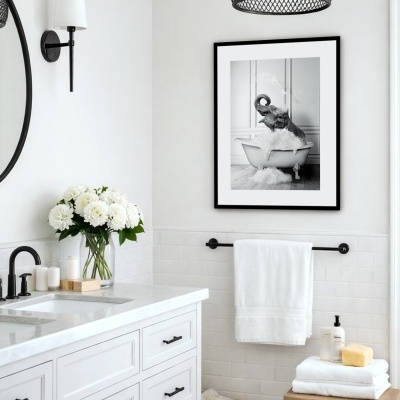 Casa de banho branca moderna com armário, torneira preta, vaso com flores, toalhas, cesto em vime, cadeira de madeira e quadro com elefante na banheira