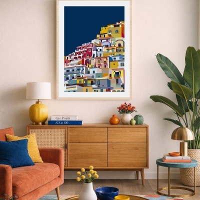 Sala de estar com sofá castanho-avermelhado, mesa de centro redonda, aparador de madeira e quadro colorido de casas.