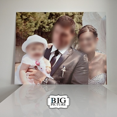 Fotografia impressa em tela de casal com bebê em ambiente exterior com vegetação