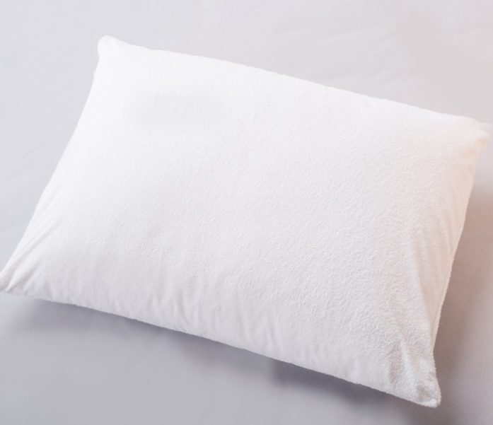 Travesseiro branco com capa texturizada sobre superfície branca