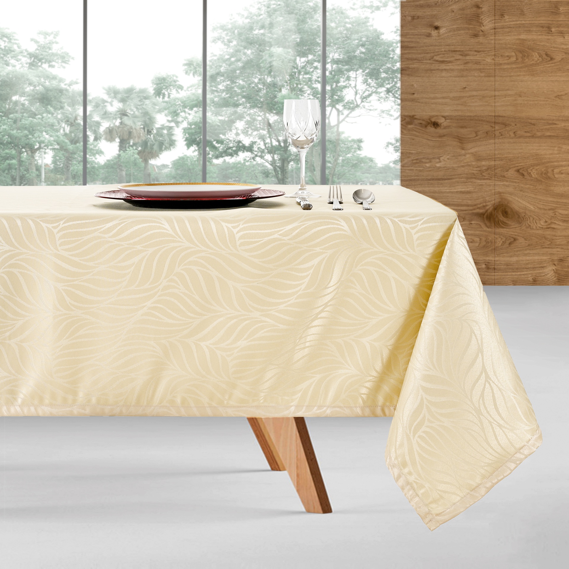 Mesa com toalha bege claro padrão ondulado e louça numa sala moderna com parede de madeira e janelas grandes