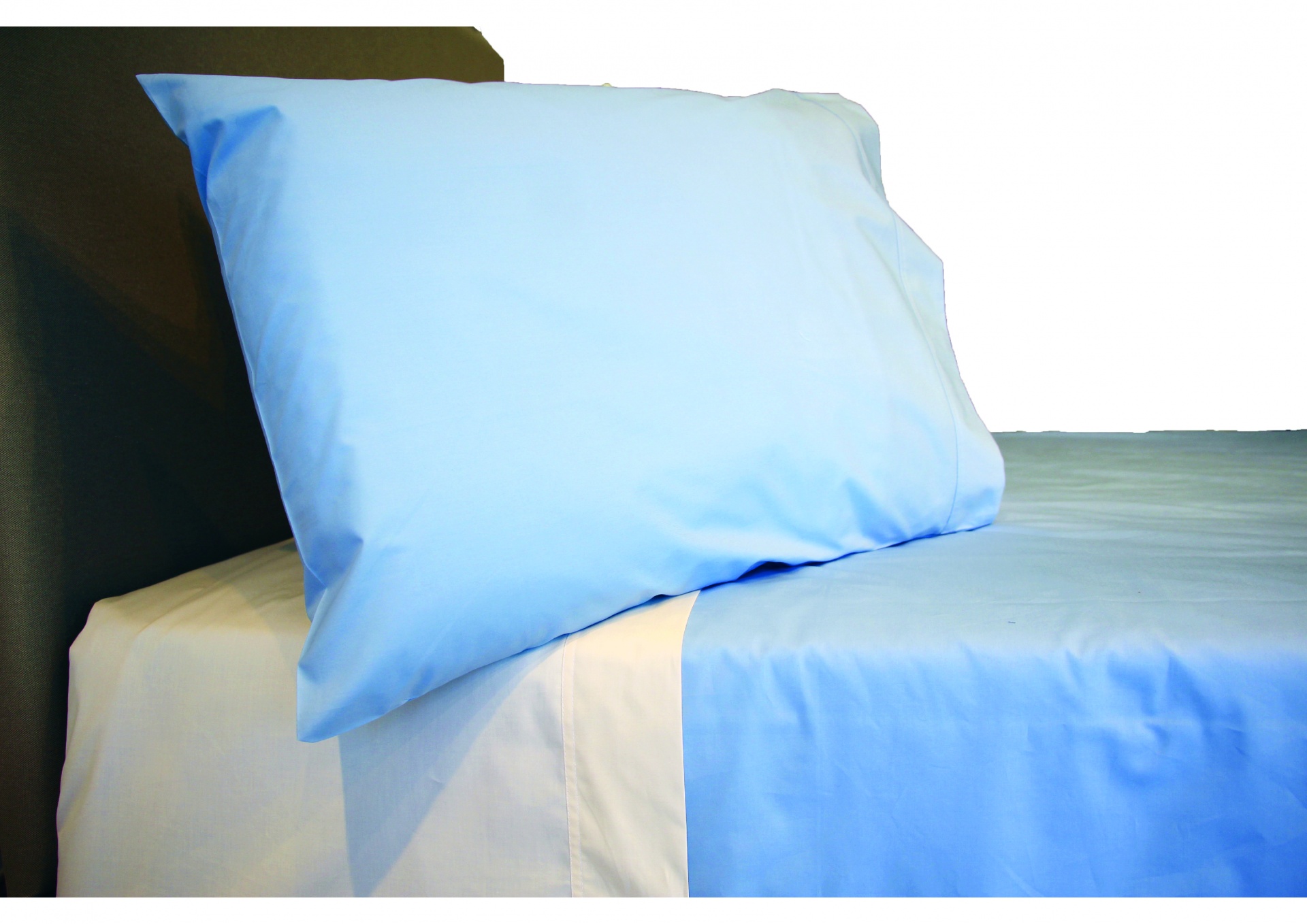 Almofada e lençol azul claro sobre lençol branco em cama