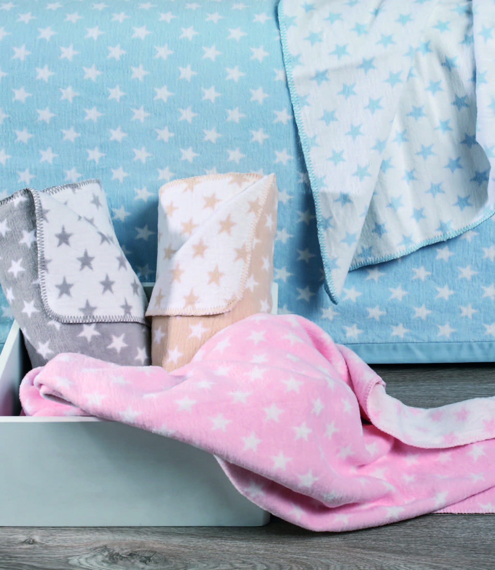 Mantinhas ou toalhas com padrão de estrelas em cores pastel dentro de uma caixa branca