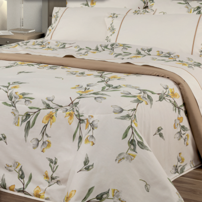 Conjunto de roupa de cama floral amarelo e verde em cama com chão de madeira