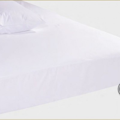 Cama com lençol impermeável branco e travesseiro