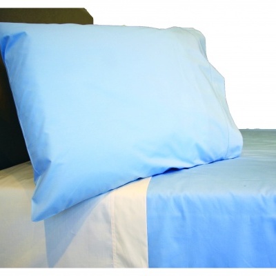 Almofada e lençol azul claro sobre lençol branco em cama