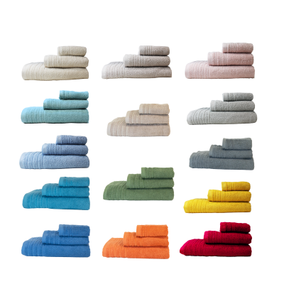 Conjuntos de toalhas em cores diversas empilhadas em grupos de três, com textura felpuda e faixas trançadas.