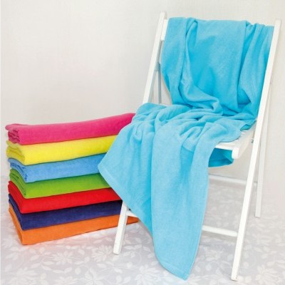 Cadeira branca com toalha azul e pilha de toalhas coloridas dobradas no chão claro