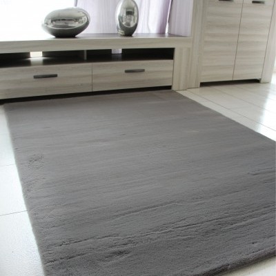 Tapete cinza macio em sala com móveis claros de madeira e cortinas brancas