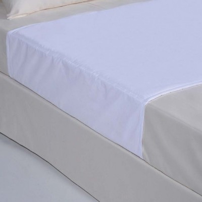 Protetor de colchão branco sobre colchão cinza claro.