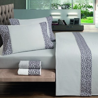 Roupa de cama branca com padrão animal nas bordas em quarto moderno
